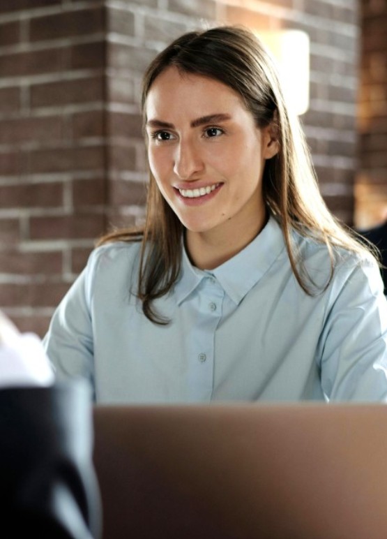 Consultante souriante en échange avec un collègue, illustrant comment rejoindre le réseau des consultants des 2 Rives